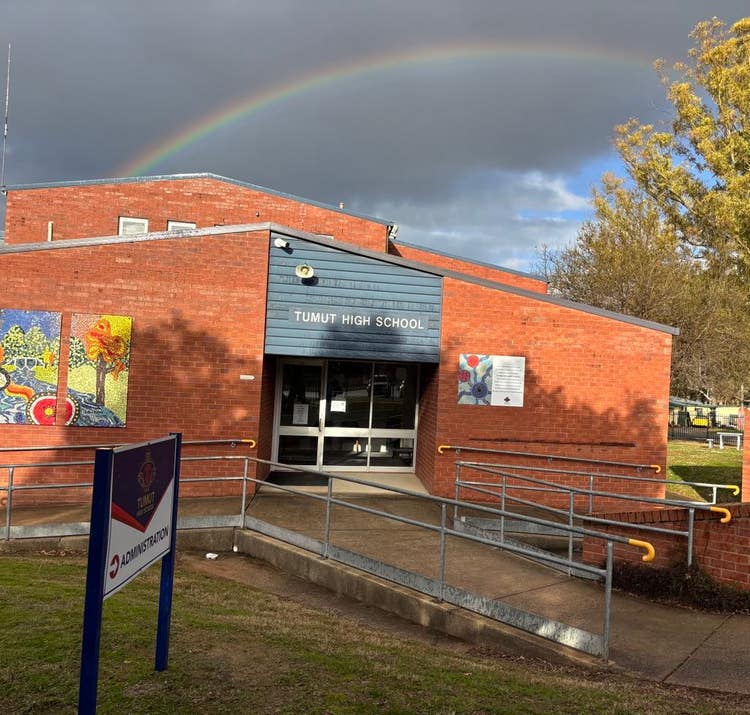Front of school Administration Building with rainbow over top of building
